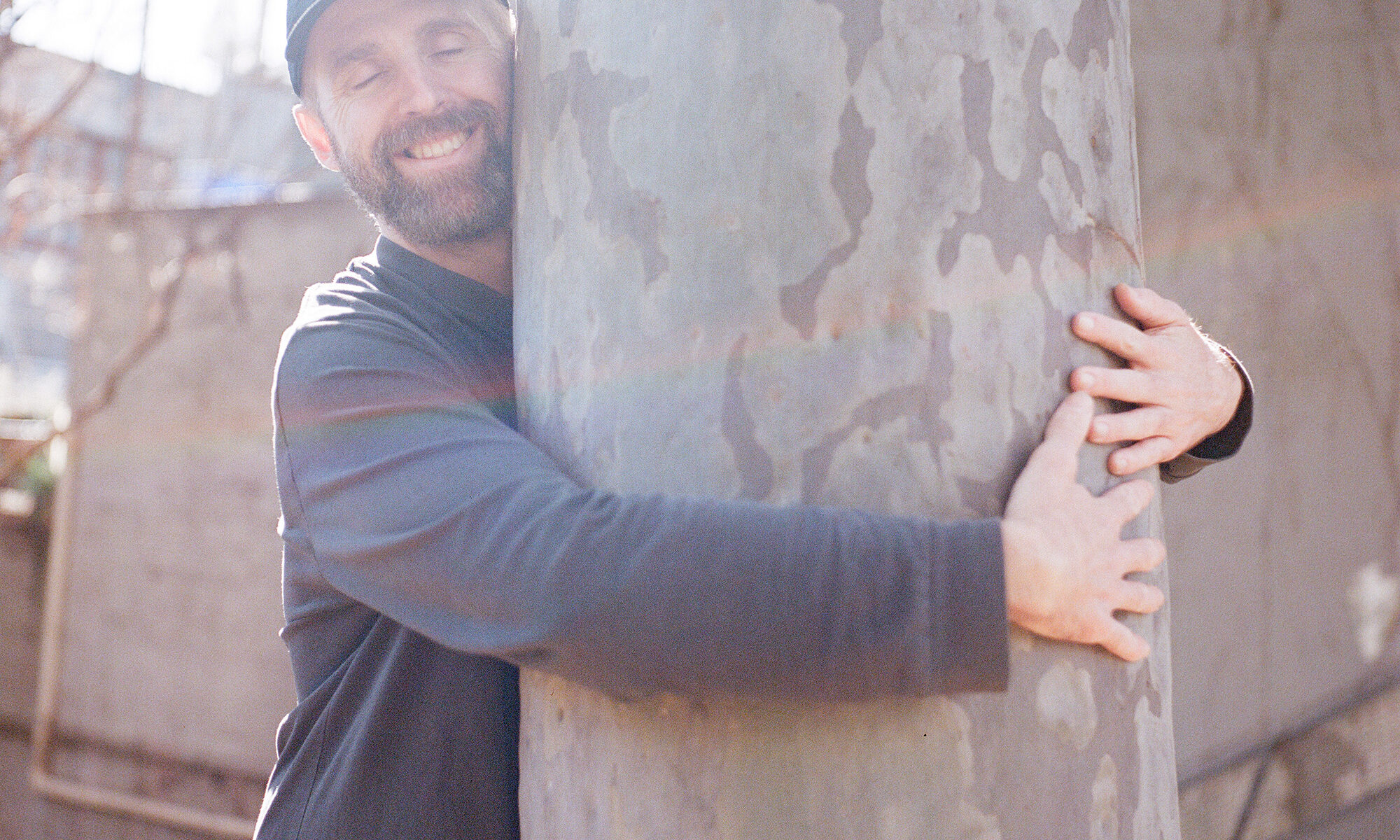 a happy person hugging a gum tree