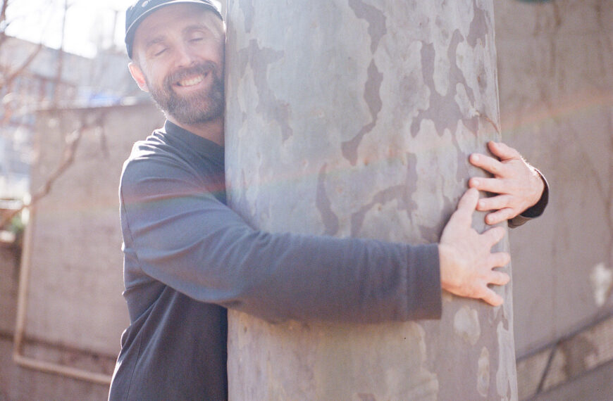 a happy person hugging a gum tree